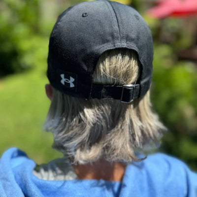 Back view of women wearing black dad cap with Sole Sister Ramblers logo.