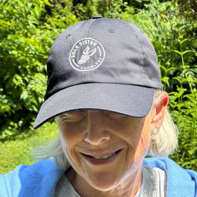 Women wearing black dad cap with Sole Sister Ramblers logo.