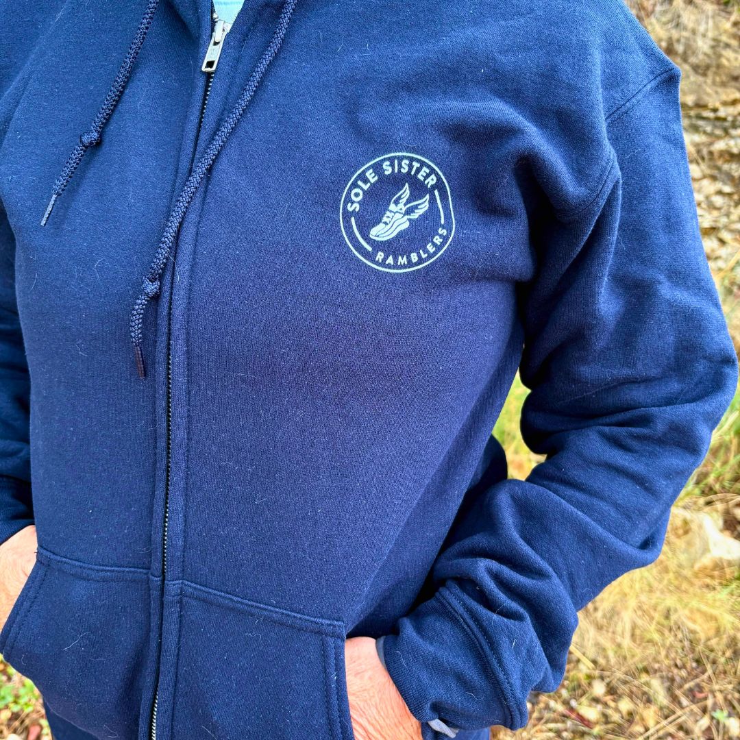 Close up of the chest of a navy blue hoodie with white Sole Sister Ramblers logo.