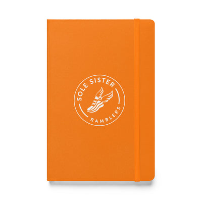 Royal orange notebook with round Sole Sister Ramblers logo.
