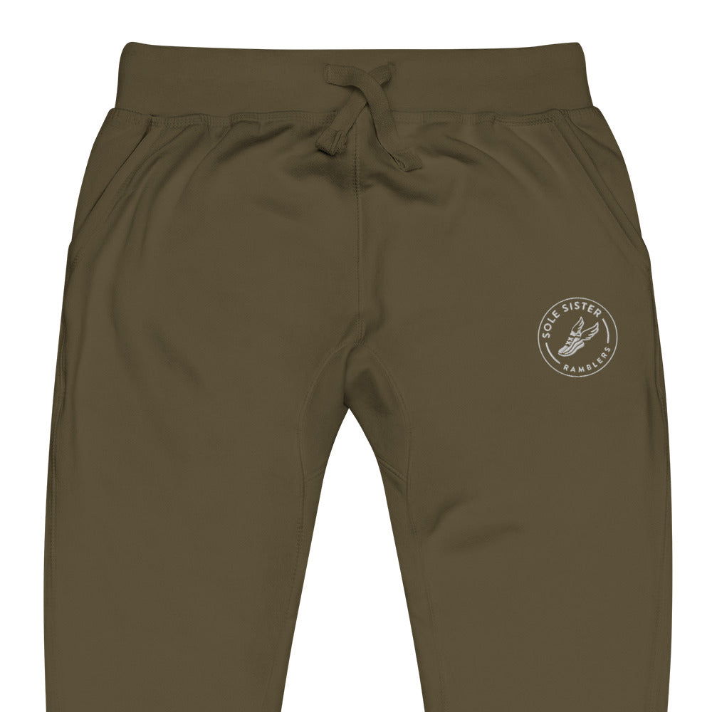 Front view of top of olive green sweatpants with round Sole Sister Ramblers logo on top leg.